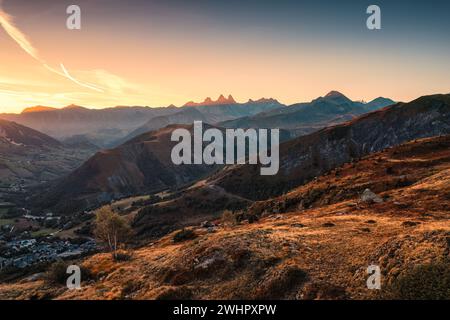 Vista aerea del paesaggio delle Alpi francesi con l'alba che splende sul massiccio dell'Arves e sulla città sciistica nella valle in autunno in Savoia, Francia Foto Stock