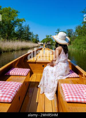 Giethoorn, donna asiatica olandese, visita il villaggio con una barca di legno e vista del famoso villaggio Foto Stock