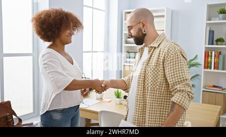 Lavoratori fiduciosi che sorridono, stringono la mano in ufficio, un incontro di lavoro di successo tra due professionisti appassionati Foto Stock