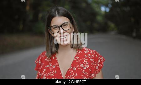 Splendida donna ispanica, radiosa di gioia, posa giocosamente con gli occhiali all'iconico santuario meiji di tokyo, trasmettendo positività e sicurezza. Foto Stock