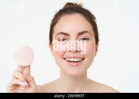 Concetto di benessere e cura della pelle. Beauty Woman mostra un tampone di cotone dopo aver lavato il viso con detergente, usando il toner per togliere mak Foto Stock