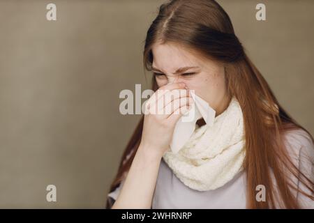 La giovane donna che soffia il naso ha influenza catarro malato malattia trattamento freddo. Foto Stock