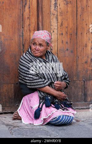 Antigua, Guatemala. Maya donna seduta, Plaza de Armas. Semana Santa. Foto Stock