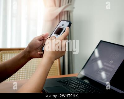 Codice QR, concetto di sicurezza per l'autenticazione a più fattori. Scanner digitale, simbolo grafico sul display della fotocamera dello smartphone tenuto in mano da un uomo d'affari, scann Foto Stock