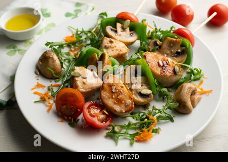 Spiedini di pollo biologici con funghi e insalata. Foto Stock