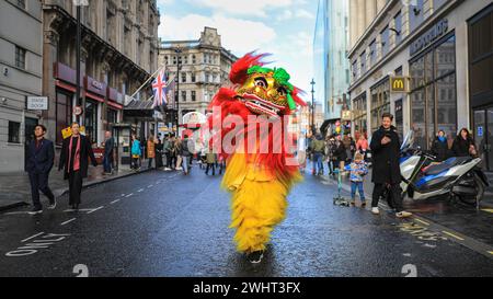 Londra, Regno Unito. 11 febbraio 2024. Due ballerini di leoni corrono lungo la strada a Soho, felici di aver finito la parte principale della sfilata prima di potersi riposare rapidamente. Artisti della colorata sfilata. Danze di leoni e draghi e una sfilata di carri fatti a mano e partecipanti a abiti tradizionali fanno parte delle celebrazioni del Capodanno cinese attraverso Chinatown e Soho di Londra. Il 2024 è l'anno del Drago nel calendario cinese. I festeggiamenti di Londra sono tra i più grandi festeggiamenti del nuovo anno lunare fuori dalla Cina. Crediti: Imageplotter/Alamy Live News Foto Stock