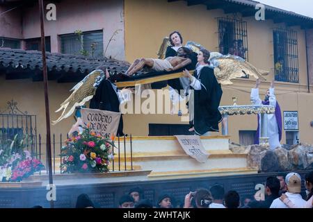 Antigua, Guatemala. L'incenso sorge intorno ad un'Anda che mostra Gesù Crocifisso, circondato da Angeli. Semana Santa Processione, Venerdì Santo. Foto Stock