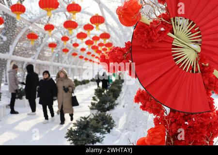 Decorazioni del capodanno cinese nella città invernale. Vicolo festivo decorato con ventilatori di carta rossa e lanterne Foto Stock