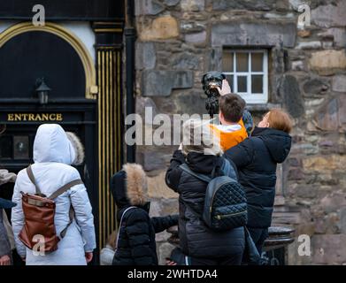 Turista toccante naso della statua del cane Bobby di Greyfriar per buona fortuna, Edimburgo, Scozia, Regno Unito Foto Stock