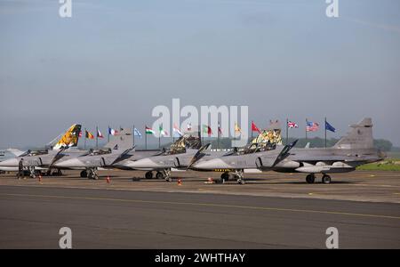 Von rechts: Vier Kampfflugzeuge der tschechischen Luftwaffe vom Typ Saab JAS-39 Gripen, dann französische Mirage 2000, dahinter Flaggen der NATO-Staaten. Flightline mit verschiedenen Kampfflugzeugen der Luftwaffen der NATO auf dem französischen Militärflugplatz Cambrai während der NATO-Luftwaffen-Übung Tiger Meet 2011. Flightline mit verschiedenen Kampfflugzeugen der Luftwaffen der NATO auf dem französischen Militärflugplatz Cambrai während der NATO-Luftwaffen-Übung Tiger Meet 2011. Regione di Cambrai Hauts-de-France Frankreich *** da destra quattro aerei da caccia dell'aeronautica militare ceca Saab JAS 39 Gripen Aircraf Foto Stock