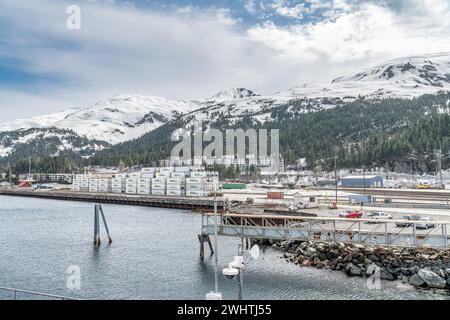 Zona portuale industriale con deposito ferroviario con montagne innevate alle spalle, Whittier, Alaska, USA Foto Stock