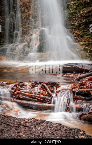 La cascata nella foresta di Rautal a Burschenplatz in inverno, Jena, Turingia, Germania Foto Stock