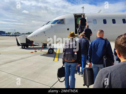 Passeggeri con bagaglio a mano a bordo di un piccolo aereo sull'asfalto, aeroporto di Duesseldorf, Renania settentrionale-Vestfalia, Germania Foto Stock