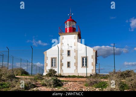 Faro luminoso oltre la recinzione a catena Foto Stock