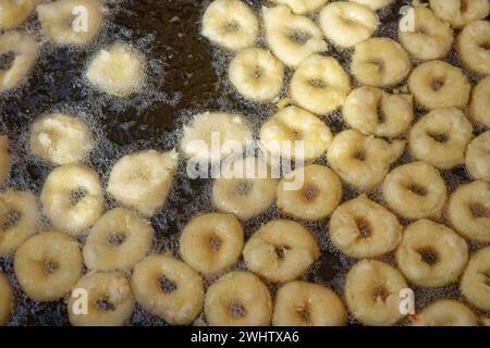 Friggere Buñuelos d'oro alla perfezione in olio bollente Foto Stock