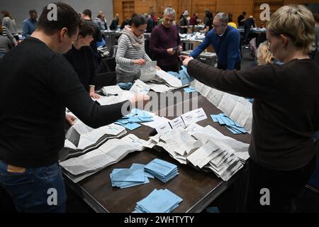 Berlino, Germania. 11 febbraio 2024. Gli assistenti elettorali lavorano durante il conteggio dei voti postali nella Max-Schmeling-Halle. A causa di numerosi problemi, le elezioni del Bundestag del 2021 a Berlino devono essere parzialmente ripetute. Questa decisione è stata decisa dalla Corte costituzionale federale il 19 dicembre 2023. Crediti: Sebastian Christoph Gollnow/dpa/Alamy Live News Foto Stock