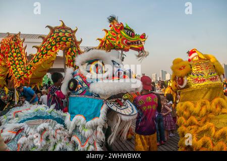 Danze di draghi e leoni contemporaneamente in uno skybar per il capodanno cinese, "l'anno del drago". Phnom Penh, Cambogia. Febbraio 2024. © Kraig Lieb Foto Stock