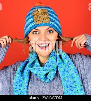 Ritratto di una bella donna con cappello, sciarpa e maglione a maglia. Ragazza sorridente in abiti invernali. Moda autunno-inverno femminile. Donna emotiva dentro Foto Stock