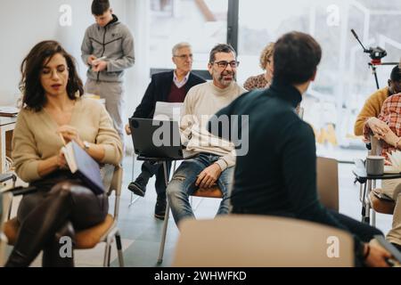 Un workshop di lavoro creativo con un gruppo diversificato di professionisti che partecipano attivamente a un ambiente di ufficio moderno. Foto Stock
