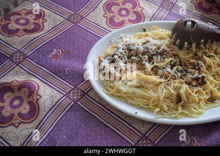 Spaghetti cotti con salsa di carne e parmigiano grattugiato sopra, pronti per essere serviti. Foto Stock