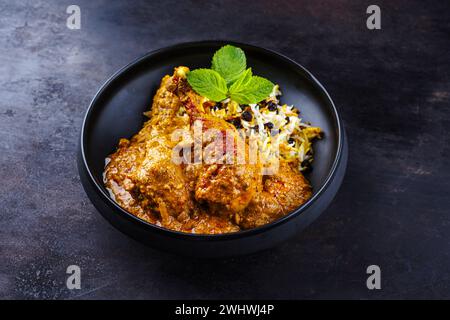 Tradizionale pollo indiano piccante Madras curry Rogan Josh con bacchette e riso servito come primo piano in una ciotola di design nordico Foto Stock
