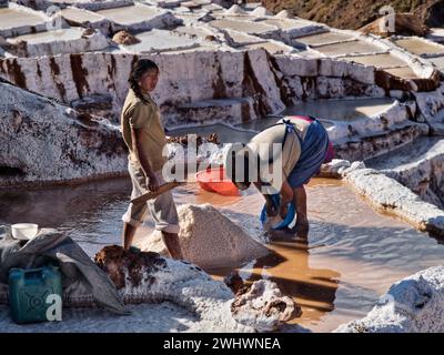 Due lavoratori nativi nelle distese saline di Maras, Cusco, Perù Foto Stock