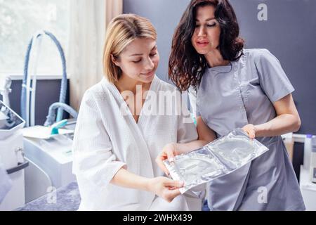 La bella estetista caucasica comunica con la sua cliente femminile. Foto Stock