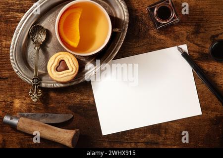Biglietto d'auguri o mockup di invito con tè all'arancia e biscotti al cioccolato Foto Stock