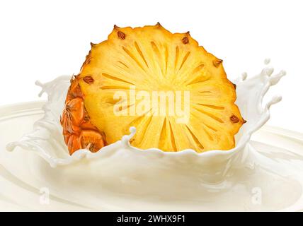 Fetta di ananas che cade in schizzi di latte isolata su sfondo bianco Foto Stock