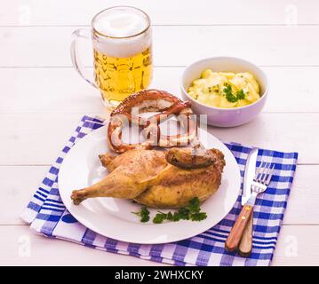 Pollo parzialmente arrosto, birra, pretzel e insalata di patate Foto Stock