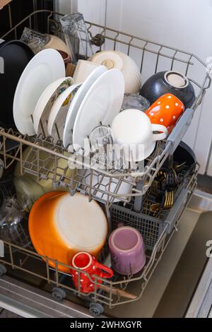 Molti piatti sporchi in lavastoviglie. Aiutare la padrona di casa, l'economia e l'ecologia. Pulizia in cucina Foto Stock