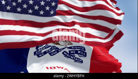 Primo piano della bandiera dello stato dell'Iowa che sventola nel vento con la bandiera degli Stati Uniti in una giornata limpida Foto Stock