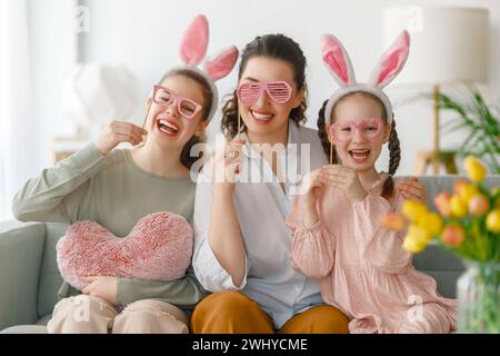 Buone vacanze. Madre e le sue figlie. La famiglia festeggia la Pasqua. Le bambine adorabili indossano orecchie da coniglio. Foto Stock