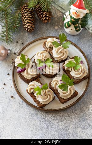 Aperitivo creativo di natale. Pate cremosi panini di aringhe su pane di segale sul tavolo delle feste. Copia spazio. Foto Stock