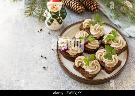 Aperitivo creativo di natale. Pate cremosi panini di aringhe su pane di segale sul tavolo delle feste. Copia spazio. Foto Stock