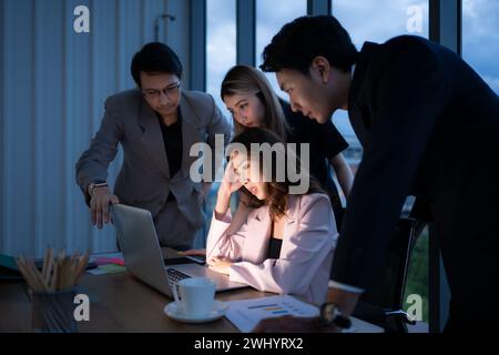 Gruppo di intermediari di borsa internazionali che lavorano attivamente di notte in carica, Una giovane donna lavora sodo per presentare un cl Foto Stock