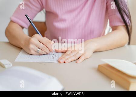 Asiatico girlÂ studente che fa l'esame mano tenendo matita scrittura risposta in università istruzione in classe scuola superiore o università st Foto Stock