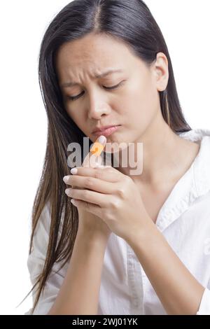 Giovane donna asiatica americana con dito ingiunito isolato su uno sfondo bianco con spazio di copia Foto Stock
