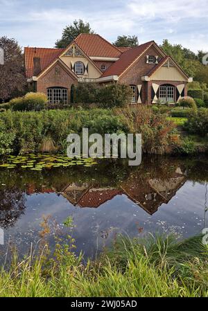 Casa sul canale Grossefehn ovest, Grossefehn, Frisia orientale, bassa Sassonia, Germania, Europa Foto Stock