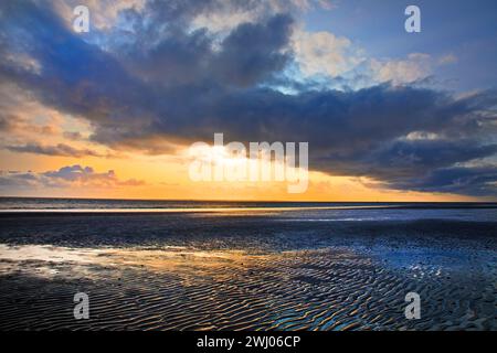 Paesaggio pianeggiante fangoso con nuvole colorate al tramonto, Isola di Norderney, Mare del Nord, Germania, Europa Foto Stock