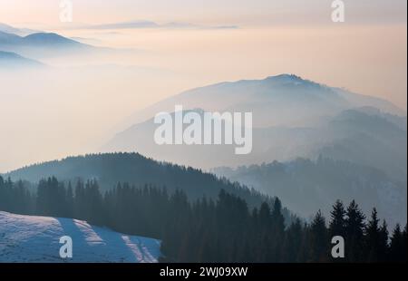 Valle di montagna avvolta da una foschia leggera alla vigilia del tramonto Foto Stock