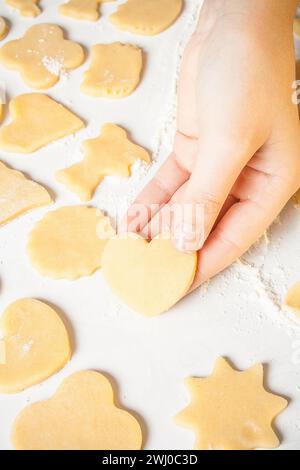 La ragazza mostra la forma del cuore con l'impasto Foto Stock