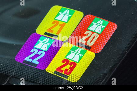 Schweizer Autobahnvignetten der Jahre 2020, 2021, 2022 e 2023 auf einer Windschutzscheibe eines Strassenfahrzeuges. (Kloten, Schweiz, 18.02.2023) Foto Stock