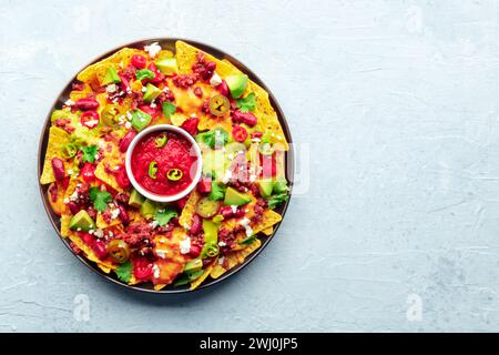 Nachos carichi. Patatine di nacho messicano con manzo, salsa guacamole e salsa al formaggio Foto Stock