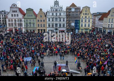 Rostock, Germania. 10 febbraio 2024. I partecipanti a una manifestazione contro l'estremismo di destra con lo slogan "mai più è ora - tutti insieme contro il fascismo” si riuniscono su Neuer Markt di fronte al municipio. Con questa azione, i residenti vogliono dare un esempio di resistenza contro le attività estremiste di destra. Gli organizzatori sono l'alleanza d'azione "Rostock nazifrei" e "Bunt statt braun e. V.". Crediti: Jens Büttner/dpa/Alamy Live News Foto Stock