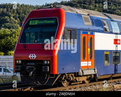 Eine Zürcher S-Bahn FFS re 450 der Linie 9 ist unterwegs nach Schhaffhausen. Hier gerade bei der Einfahrt in den Bahnhof Hüntwangen-Wil im Kanton Züri Foto Stock