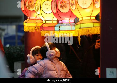 Yokohama, Giappone. 11 febbraio 2024. I bambini vedono le lanterne nella Chinatown di Yokohama, Giappone, 11 febbraio 2024. I turisti sono venuti a Chinatown per godersi l'atmosfera festosa del Festival di primavera. Crediti: Yue Chenxing/Xinhua/Alamy Live News Foto Stock