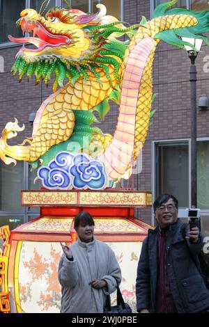 Yokohama, Giappone. 11 febbraio 2024. I turisti posano per le foto con le lanterne nella Chinatown di Yokohama, Giappone, 11 febbraio 2024. I turisti sono venuti a Chinatown per godersi l'atmosfera festosa del Festival di primavera. Crediti: Yue Chenxing/Xinhua/Alamy Live News Foto Stock