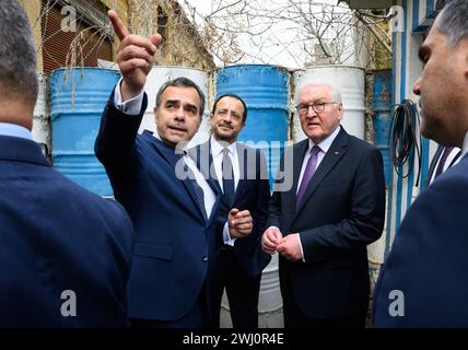 12 febbraio 2024, Cipro, Nikosia: Il presidente tedesco Frank-Walter Steinmeier (r) e Nikos Christodoulides (M), presidente della Repubblica di Cipro, stanno insieme a Constantinos Yiorkadjis (l), sindaco di Nicosia, sulla "linea verde". La "linea verde” è la zona cuscinetto demilitarizzata monitorata dalle Nazioni Unite (ONU) tra Cipro del Nord occupata dalla Turchia e la Repubblica di Cipro. Il presidente federale Steinmeier è il primo presidente tedesco a visitare il paese nel Mediterraneo orientale, 20 anni dopo l'adesione del paese all'Unione europea (UE) e 50 anni dopo la divisione Foto Stock