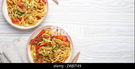 Due ciotole con Chow Mein o lo Mein, tradizionali spaghetti cinesi con carne e verdure, serviti con bacchette Foto Stock